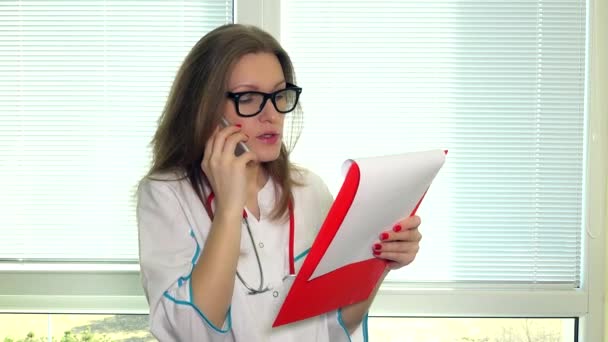 Ευχάριστο είδος γυναίκα γιατρό έχοντας συνομιλία με τον ασθενή στο κινητό τηλέφωνο — Αρχείο Βίντεο