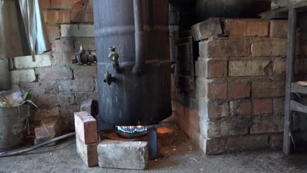 Aparelho de destilação de álcool em chamas e o homem carrega jarra com álcool. 4K — Vídeo de Stock