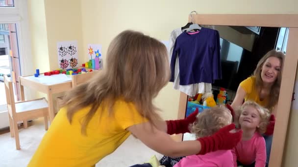 Bébiszitter nő játszó kisgyermek lány közel tükör — Stock videók