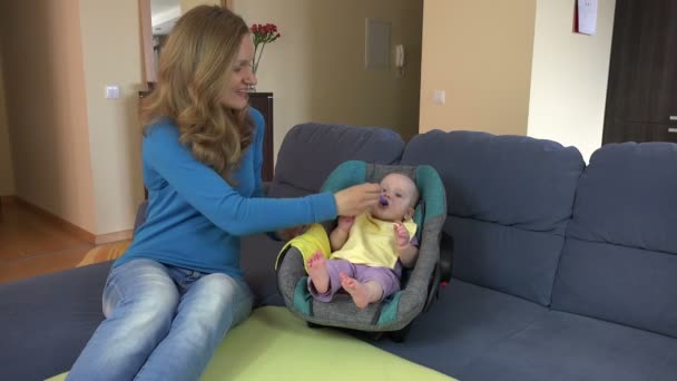 Kärleksfull mor föda dotter baby med sked hemma. 4k — Stockvideo