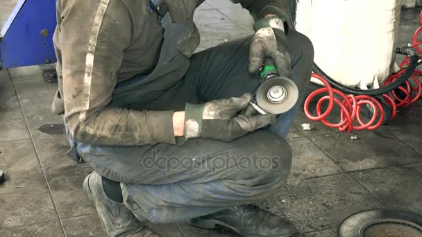Auto Μηχανικός Πολωνικά σκουριασμένα μπουλόνια με ηλεκτρικό μύλο εργαλείο κοντά ανυψωμένη αυτοκίνητο — Αρχείο Βίντεο