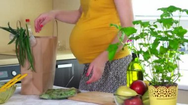 hamile kadın boşaltma alışveriş poşetinin mutfak