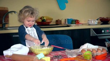 Komik çocuk un ile oynuyor. Kız hamur yoğurmak. Komik un ile lekeli kız