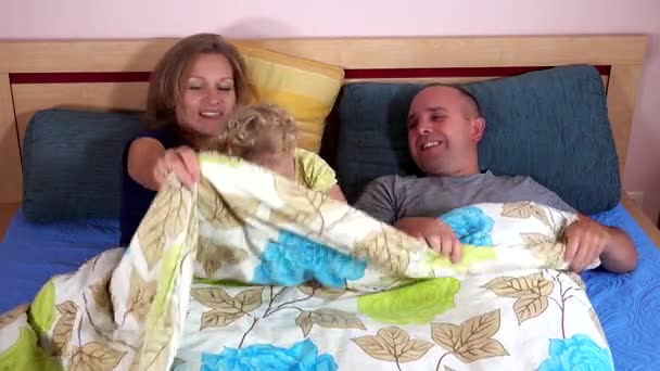 Lycklig familj mamma far och småbarn flicka ha kul under wrap — Stockvideo