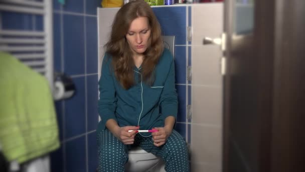 Stressad kvinna flicka i blå pyjamas holding graviditetstest väntar på resultatet — Stockvideo