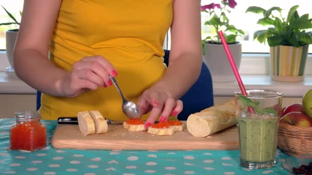 Gravid kvinna händer förbereda baguette smörgås med kaviar — Stockvideo