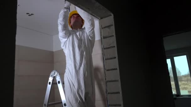 Trabalhador profissional fazendo furos de teto drywall para instalação de iluminação — Vídeo de Stock