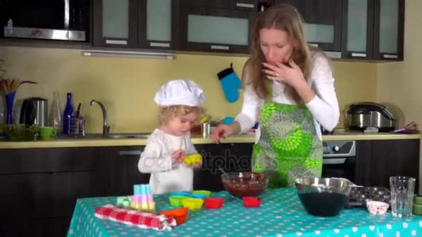 Mulher e sua filhinha bonitinha preenchendo casos de muffin — Vídeo de Stock