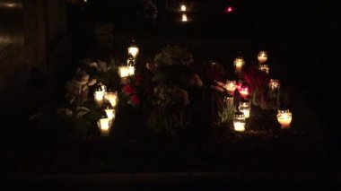 çiçek, mum ışığı kara günü mezarlığındaki mezar taşı üzerinde. 4k