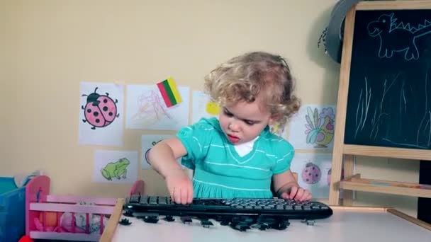 Linda hija chica destruyendo teclado — Vídeo de stock