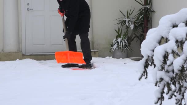Человек чистый снег с лопатой с домашней тропы холодное зимнее время. 4K — стоковое видео