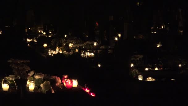 Tumba del cementerio con la luz de las velas y flores en la noche. 4K — Vídeo de stock