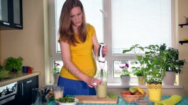 Hamile kadın karışımı süt ve doğal meyve mutfak blender aracıyla kokteyl