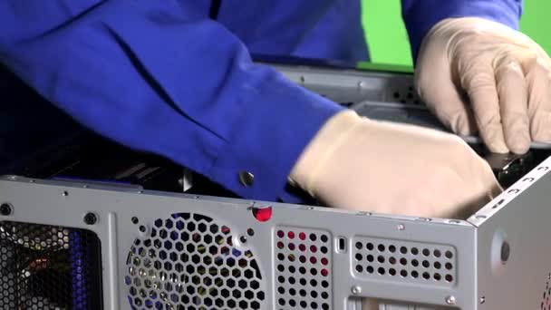 Le mani con i guanti collegano i fili e chiudono la copertura della custodia del computer riparata — Video Stock