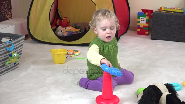 Linda niña de un año jugando con anillos de colores . — Vídeos de Stock