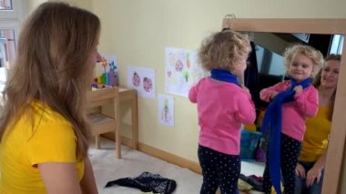 Güzel bebek kız ölçü şal ayna ve ona yardım anne tarafından