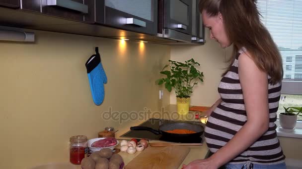 Mujer embarazada cocinando en la cocina casera — Vídeo de stock