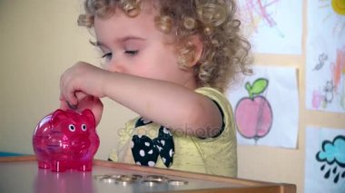 Sevimli küçük çocuk bir kumbara tasarruf