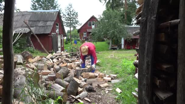 Starker Dorfbewohner, der natürliche Holzbrennstoffe und ländliche Häuser vorbereitet. 4k — Stockvideo