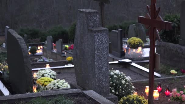 Pedras de túmulo de cemitério rural e velas ardem à noite perto da floresta. 4K — Vídeo de Stock