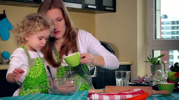 Donna versare olio nella pasta torta e piccola aiutante figlia ragazza mescolando con cucchiaio — Video Stock