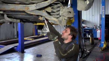 otomatik mekanik spanner aracı ile araba altında çalışıyor. El.