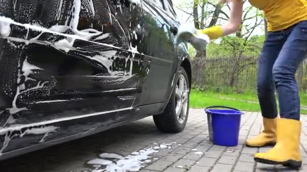 Mulher lavando automóvel ao ar livre. Tiro portátil . — Vídeo de Stock