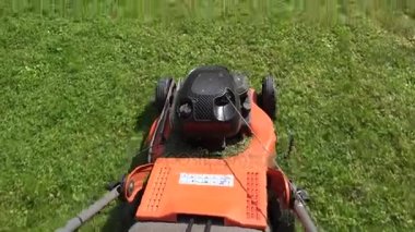 Yalınayak çalışan adam adam trim çayır çim çim biçme makinesi ile kesme. 4k