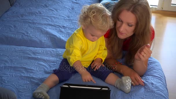 Tablet bilgisayar evde kanepede ile oynayan anne ve bebek çocuk. — Stok video