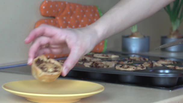 Kvinnlig hand sätta köttpajer på gula pan i kök. 4k — Stockvideo