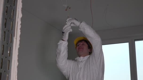 Elektriker man med hjälm skruva glödlampa — Stockvideo