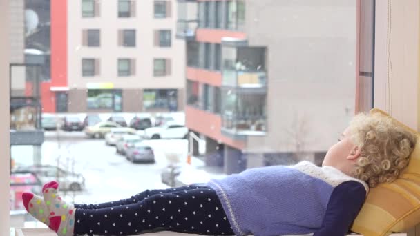 Üzgün çocuk ısıtıcı yakın pencere ve kara seyir yatan düşmek — Stok video