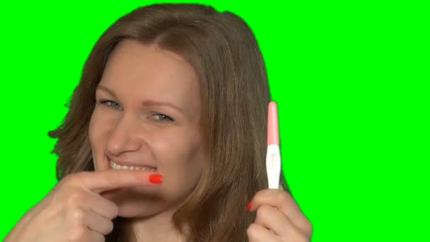 Счастливая женщина лицо показывает положительный тест на беременность и большой палец вверх жест — стоковое видео