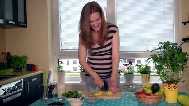 Hermosa mujer embarazada en la cocina con alimentos saludables — Vídeos de Stock