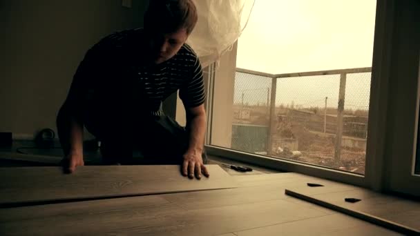 Trabalhador que estabelece um piso com placas de piso laminado — Vídeo de Stock