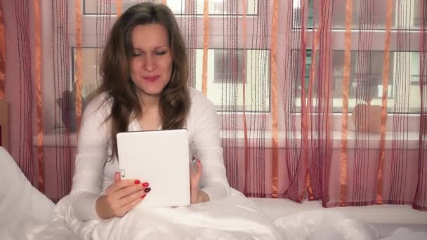 Feminino usando computador tablet sentado na cama — Vídeo de Stock