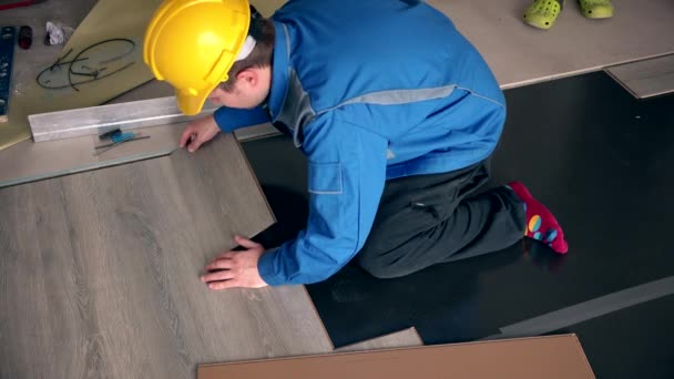 Dřevěné laminátové podlaze ležel muž profesionální Tesař — Stock video