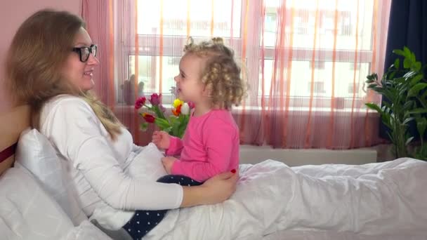 Skvělá dcera dívka se snaží matka oko brýle sedí na posteli. Rodina dívky
