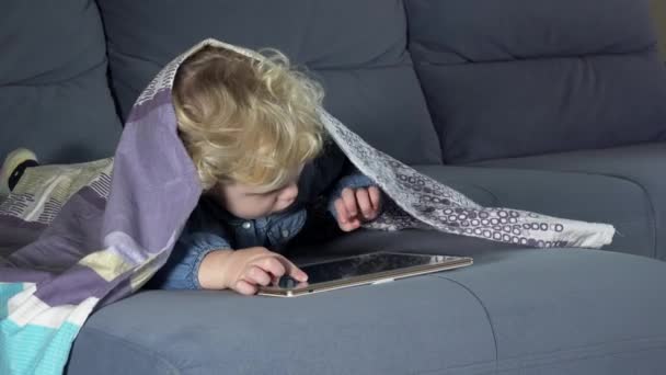 Enfant accro à l'ordinateur touchant écran de tablette. Fille couverte de plaid — Video