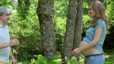 Gri kafa adam onun hamile kadın öpücüğüne bloom sarımsak getirmek ve göbek okşamak