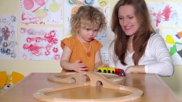 Criança feliz e mãe brincando com trem de brinquedo . — Vídeo de Stock