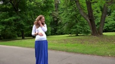 Bekleyen anne parkta yürüyüş. Flycam hareketi çevresinde