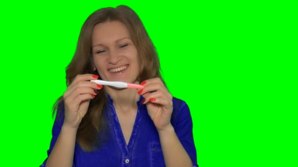 Smiling woman holding positive pregnancy test and show it to camera — Stock Video