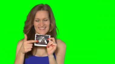 Mutlu genç erkek bebeğini karın fotoğraf kamera ve gülümseme için gösterilen