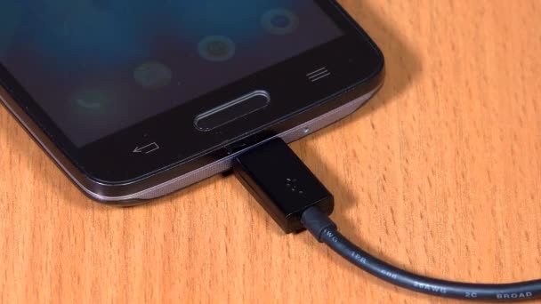 femme main débrancher câble noir à l'appareil intelligent. gros plan 