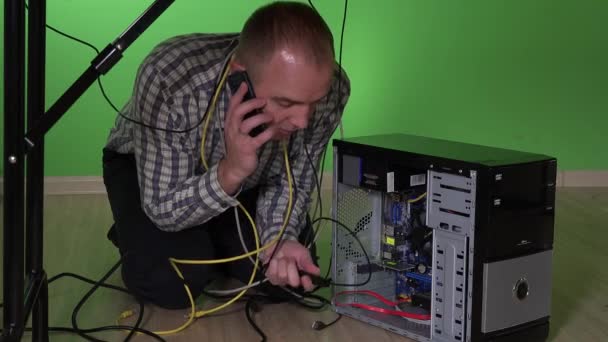 Bilgisayarında sorun olan ve cep telefonu ile ilgili yardım arıyor iş adamı — Stok video