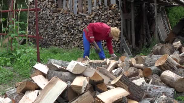 Farmer guy chops wood near woodshed. 4K — Stock Video