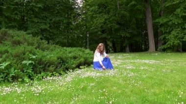 Bekleyen anne park çayırda papatya çiçek toplama. Steadycam