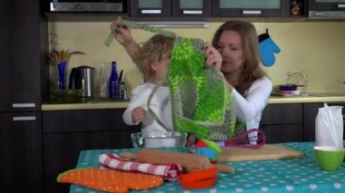 Anne ve kızı kızla aynı önlük yemek pişirmek için hazırlanıyor