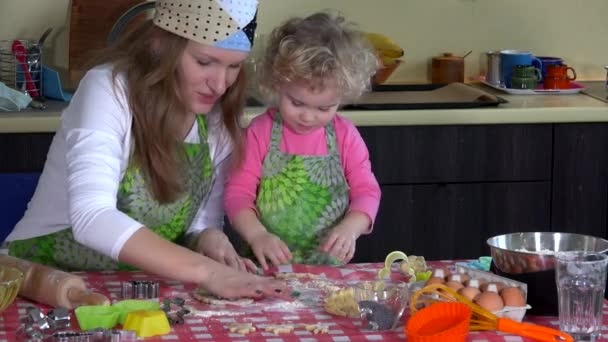 Mutter und Kind schneiden in der heimischen Küche Weihnachtsplätzchen aus Teig — Stockvideo